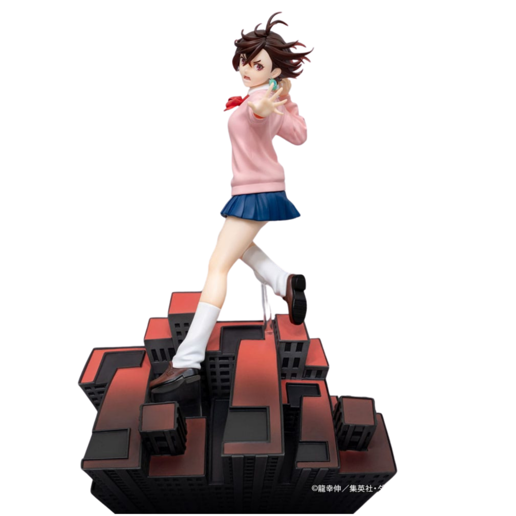 Dressta Sammelfigur von Momo Ayase aus Dandadan im Sprung über einer Base mit rotem Dandadan-Logo und Häuserkulisse.