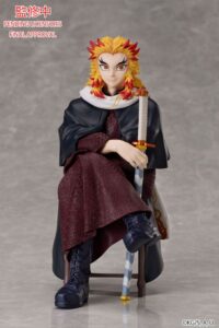 Sammelfigur von Kyōjurō Rengoku aus Demon Slayer im dunkelroten Kimono sitzend auf einem Stuhl mit Schwert und gelb-rotem Haar.