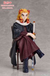 Sammelfigur von Kyōjurō Rengoku aus Demon Slayer im dunkelroten Kimono sitzend auf einem Stuhl mit Schwert und gelb-rotem Haar.