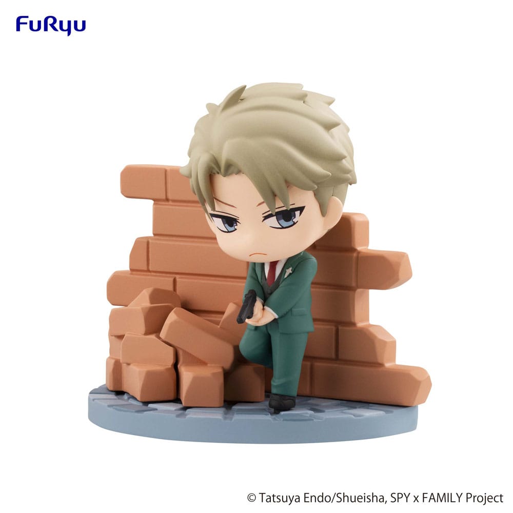FuRyu Hold Figures Chibi-Figur von Loid Forger aus SPY x FAMILY im grünen Anzug mit Pistole vor einer Backsteinmauer.