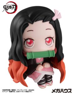 Sitzende Look Up Chibi-Figur von Nezuko Kamado aus Demon Slayer im rosa Kimono mit Bambus-Knebel im Mund.