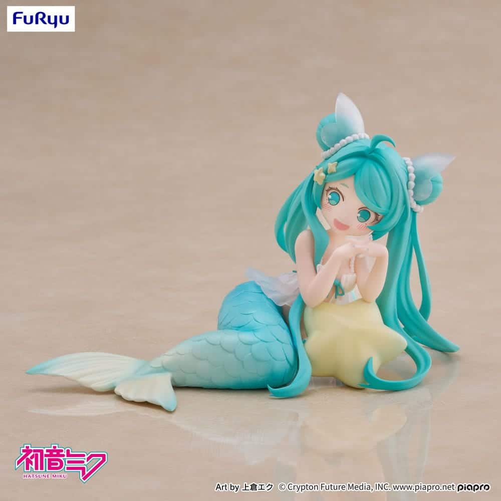 FuRyu Hatsune Miku Figur als Meerjungfrau in Mermaid Princess Version mit türkisblauen Haaren und gelber Flosse auf dem Boden.